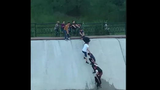 Group of people rescue a dog stuck in a water reservoir